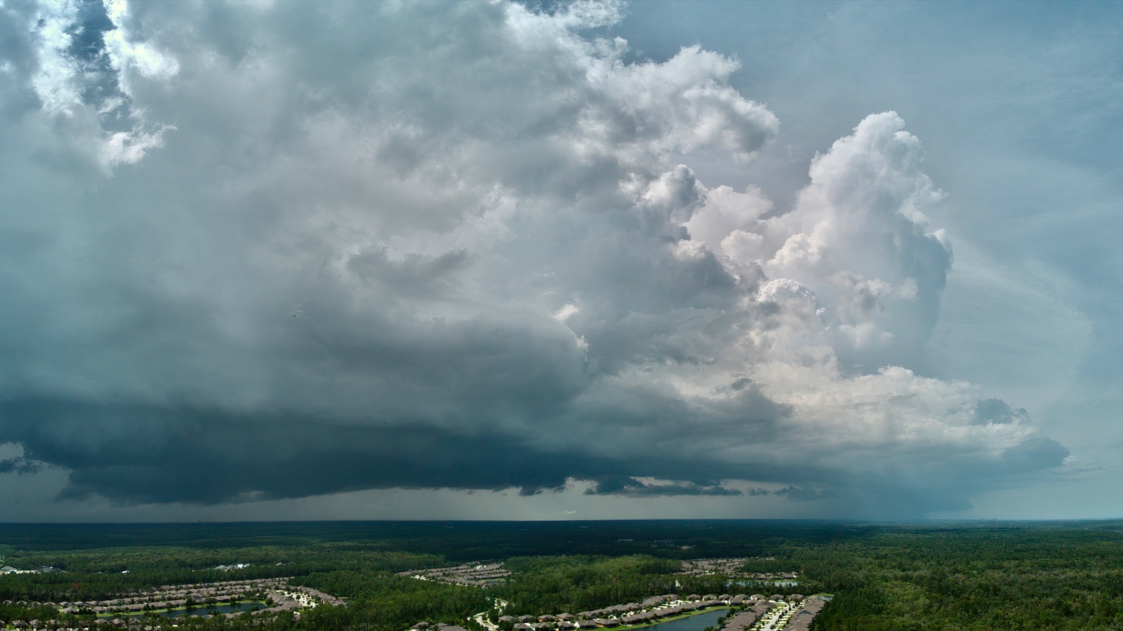 Aerial view of a large thunderhead over a suburban landscape